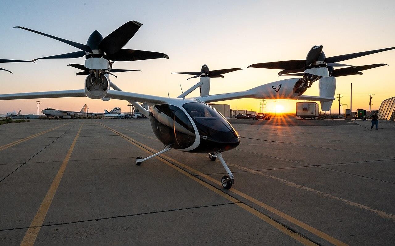 An electric vertical take-off aircraft on a runway at sunset